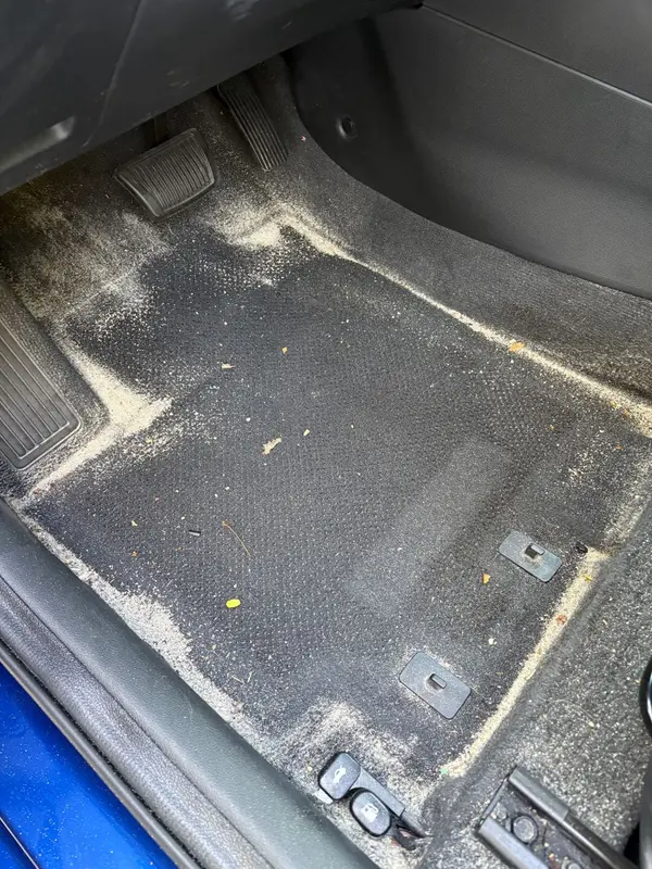 Before: driver footwell carpet covered in beach sand, leaves and grit