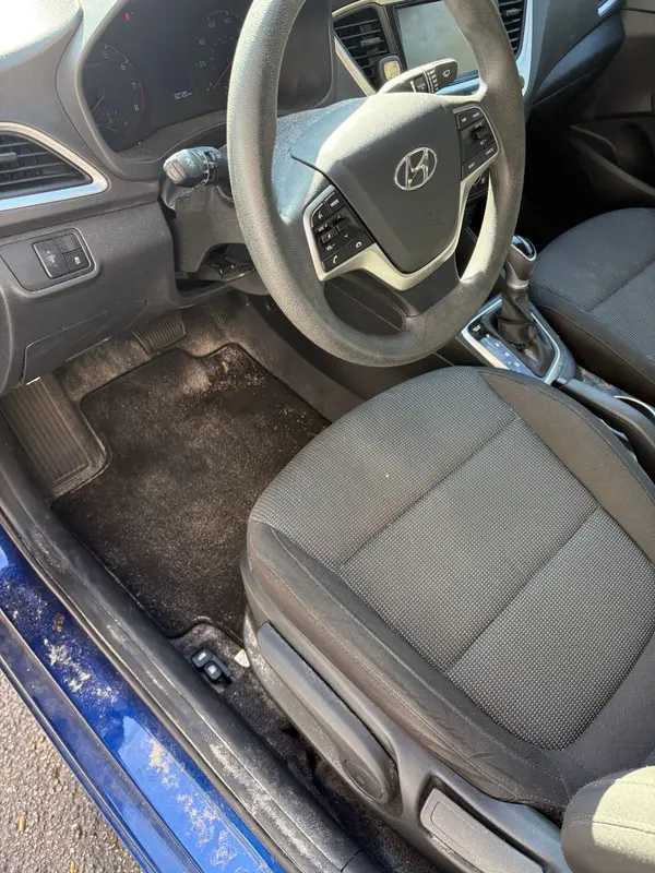 Hyundai Accent driver area before: dusty mat and sandy door sill