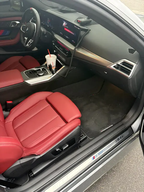 BMW passenger footwell before: debris on the carpet and mat
