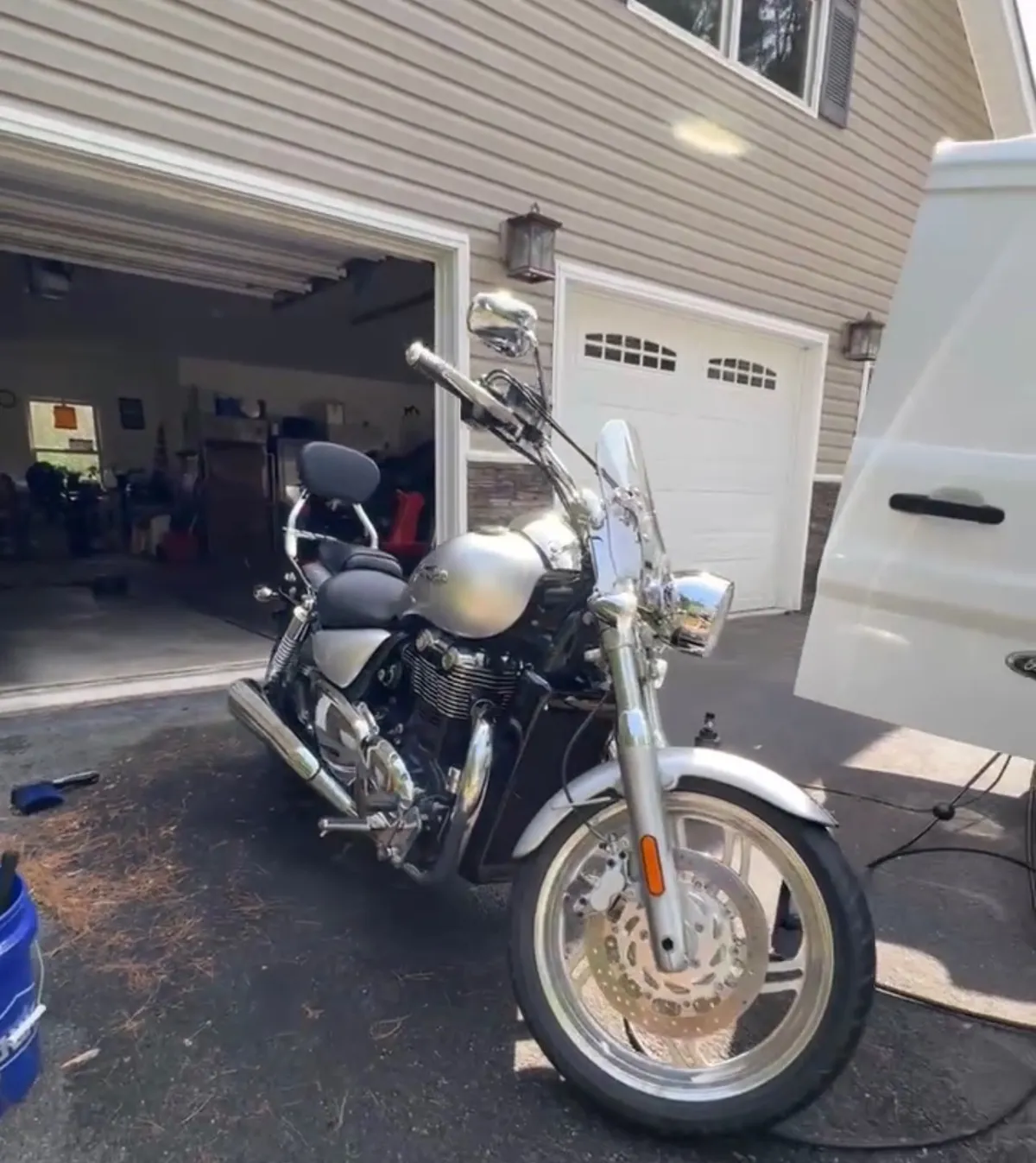 Silver and chrome cruiser motorcycle after a detail in a customer driveway